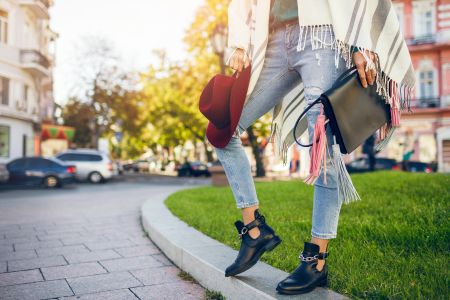 close-up-woman-legs-wearing-black-leather-boots-jeans-footwear-spring-trends-holding-bag-1