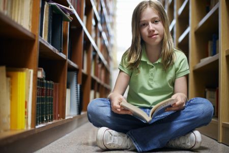 dziewczynka siedzi na podłodze w bibliotece